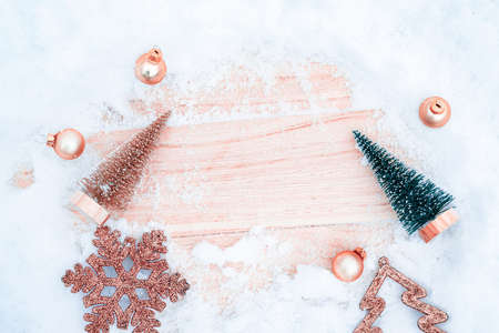 Christmas frame. Winter wooden decoration background. Xmas board with old rustic wall, white frozen snow, golden balls and gift box. Top view with copy spaceの写真素材