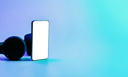 Screen mockup. Mobile smartphone technology blank screen. Mock up smart phone device, audio headphones on neon gradient banner. Game design, mobile application presentation or portfolio mockupsの写真素材