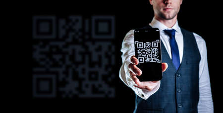 Code scan icon. Digital mobile smart phone with qr code scanner on smartphone screen for payment pay, scan barcode technology on black background. Online bill payment conceptの写真素材