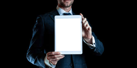 Device mockups. Businessman holding mobile tablet blank screen. Smart technology device mock up isolated on black banner background. Mockup for application or website design projectの写真素材