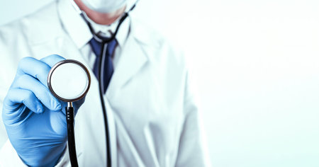 Stethoscope hand medical background. Happy doctor in hospital uniform, blue gloves holding stethoscope isolated on white. Diagnostic, prevention of women diseases, healthcareの写真素材