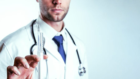 Syringe needle medical injection. Selective focus, doctor hand in blue gloves holding syringe with needle. Hospital white doctor gown, stethoscope. Syringe with flu vaccine with copy spaceの写真素材