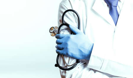 Stethoscope background. Happy doctor in hospital wearing scrubs, blue gloves, provide checkup, examine patient in clinic. Medical service, consultation or education, healthy lifestyle conceptの写真素材