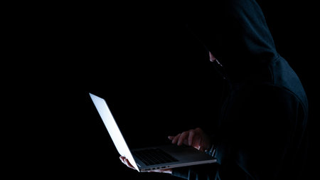 Cyber security hacker concept. Internet web hack technology. Digital laptop in hacker man hand isolated on black banner. Data protection, secured internet access, cyber securityの写真素材