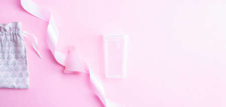 Menstrual cycle sanitary cup. Pink ribbon with menstrual cup. Menstruation feminine period. Sanitary hygiene banner. Use menstrual cup inside vaginaの写真素材