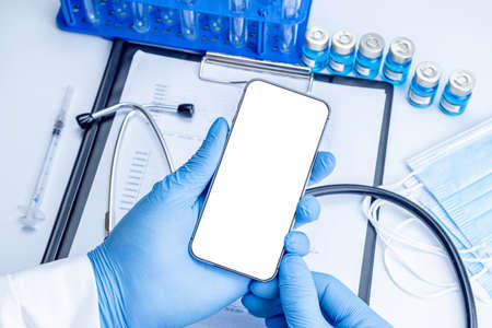 cell phone mockup. Syringe with needle, hospital healthcare charts, doctor stethoscope and black smartphone with blank screen for medical equipment background with clipping path, copy spaceの写真素材