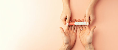 Pregnancy test kit. Female hand hold positive pregnant test with silk ribbon on pink banner background. Medical healthcare gynecological, pregnancy fertility maternity people conceptの写真素材