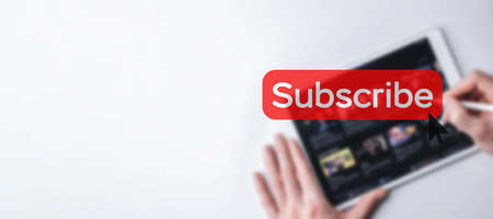 subscribe button. Online video subscription red button. Internet service on laptop digital tablet blurred banner background. Visual contents concept. social networking serviceの写真素材