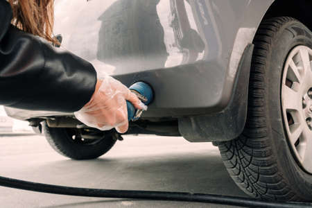 Filling car petrol. Pump gas fuel at gasoline oil station for nozzle tank. Black handle of the refueling gun.の写真素材