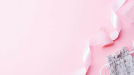 Menstrual cycle sanitary cup. Pink ribbon with menstrual cup. Menstruation feminine period. Sanitary hygiene banner. Use menstrual cup inside vaginaの写真素材