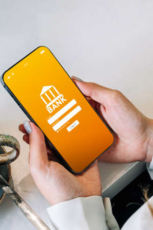 Mobile banking. Woman holding smartphone with internet online bank application. Debit card wallet app. Save money business concept.の写真素材