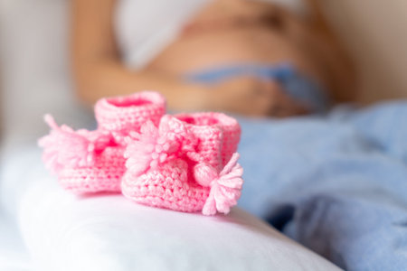 Pregnancy shoes baby. Pregnant mother girl hold small child shoe for baby. Concept maternity,...