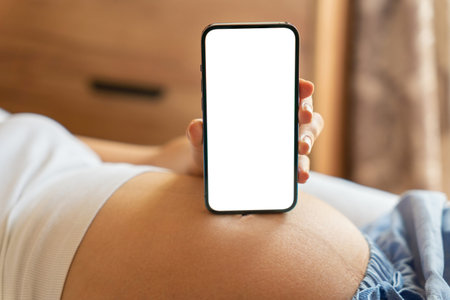 Smartphone mockup. Pregnant woman holding smartphone. Mobile pregnancy online maternity application...
