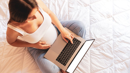 Pregnancy mockup display. Pregnant woman holding blank laptop screen. Mobile pregnancy online maternity notebook mock up. Concept maternity, pregnancy, childbirthの写真素材