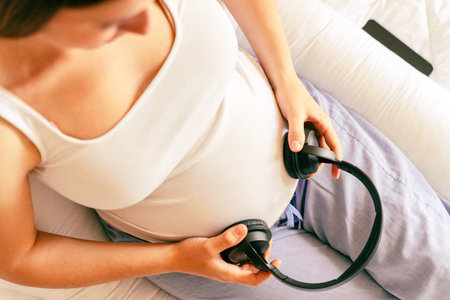 Pregnant music woman listen. Mother belly listen headphones sound. Pregnancy woman listening to music. Concept maternity, pregnancy, childbirthの写真素材