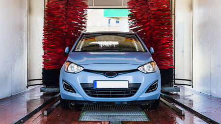 car washing machine. Auto brush washer clean blue car on automatic carwash station. Automated car washing machine backgroundの写真素材
