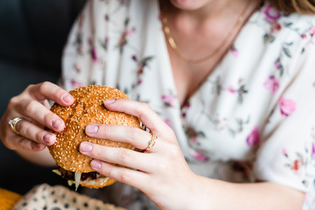 Hamburger eating woman. Hungry Girl Biting Burger. Fast food, people and unhealthy eating concept