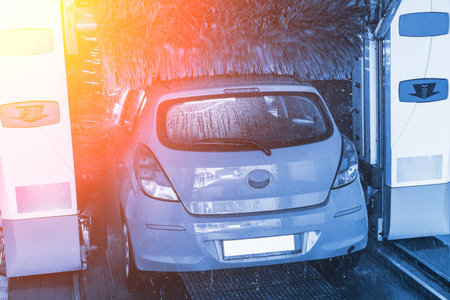Car washing automatic carwash. Brush washer clean blue auto car on automatic car wash station....