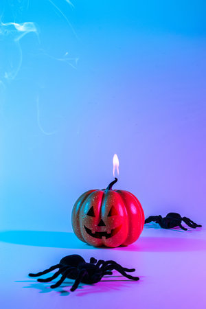 Halloween background. Scary spooky pumpkin, black night spider on night neon halloween backdrop. Minimalistic background for autumn holidays. Space for textの写真素材