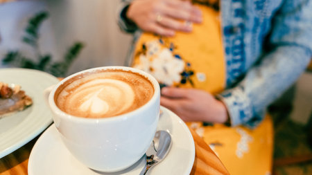 Pregnant woman coffee drink. Lifestyle morning with happy pregnancy girl drink espresso coffee. Represent breakfast, energy, freshness or great aroma conceptの写真素材