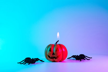 Scary spooky pumpkin, black night spider on night neon halloween background. Minimalistic background for autumn holidays. Space for textの写真素材