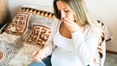Pregnancy fever temperature check. Pregnant woman holding thermometer, check fever flu temperature. Pregnancy girl sick. Concept maternity, pregnant, childbirthの写真素材