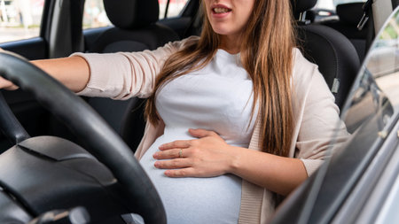 Pregnant driving car. Young smiling pregnancy woman driving car. Safety pregnant young mom driving conceptの写真素材