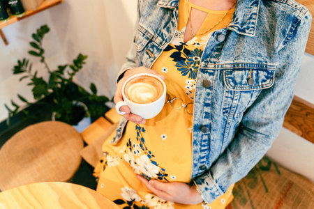 Pregnant coffee drink woman. Happy pregnancy girl drink hot coffee in restaurant. Represent breakfast for energy and freshness conceptの写真素材