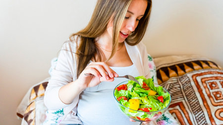 Pregnancy eating healthy salad. Happy pregnant woman eating nutrition food. People lifestyle food conceptの写真素材