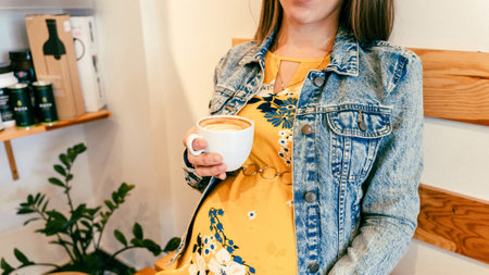 Pregnant woman coffee drink. Lifestyle morning with happy pregnancy girl drink espresso coffee. Represent breakfast, energy, freshness or great aroma conceptの写真素材