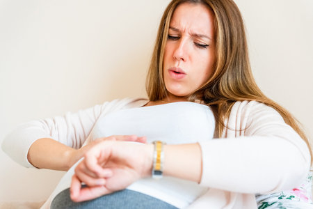 Pregnant contractions time. Pregnancy woman watching clock, holding baby belly. Childbirth time, contractions pain. Concept of pregnant, maternity, expectation for baby birthの写真素材
