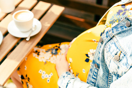 Pregnant woman drink coffee. Lifestyle morning with happy pregnancy girl drink espresso coffee. Concept for coffee product advertisingの写真素材