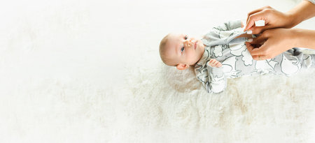 baby newborn baby banner. Happy cute baby kid girl lying on white bed background. Cute little boy lying at bed. Childhood bath conceptの写真素材