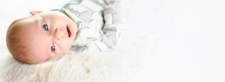 baby background baby banner. Happy cute baby kid girl lying on white bed background. Cute little boy lying at bed. Childhood bath conceptの写真素材