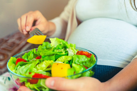 Pregnancy eating healthy salad. Happy pregnant woman eating nutrition food. People lifestyle food conceptの写真素材