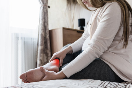 Pregnancy leg pain woman. Pregnant girl have foot cramp, ankle leg pain doing health massage exercise. Leg cramps during pregnancyの写真素材