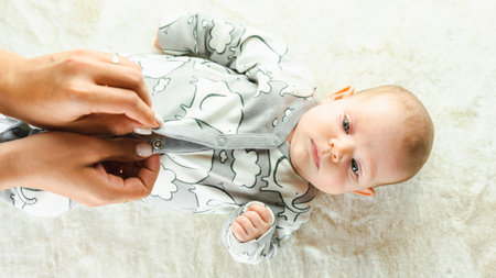 Baby kid cute baby banner. Happy cute baby girl lying on white bed background. light background. little child. serious emotionの写真素材
