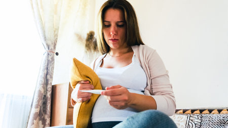 Pregnant thermometer temperature check. Pregnancy woman holding thermometer, check fever flu temperature. Pregnant girl sick. Concept of pregnancy, maternity, expectation for baby birthの写真素材