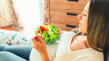 Pregnancy eating healthy salad. Happy pregnant woman eating nutrition food. People lifestyle food conceptの写真素材