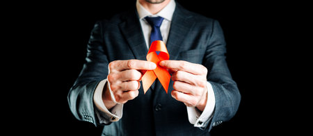 Hiv aids. Red ribbon in hiv world day isolated on dark background. Man holding awareness aids and cancer symbol. Health, Medical sign. copy space.の写真素材