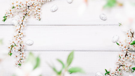 Easter spring background. Sakura flower, white happy easter egg on wooden spring background. Easter wallpaper. Spring holiday concept.の写真素材