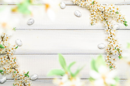 Easter background wood. Sakura blossom flower, white happy easter eggs on wood spring background. Easter design. Top view. Flat lay.の写真素材