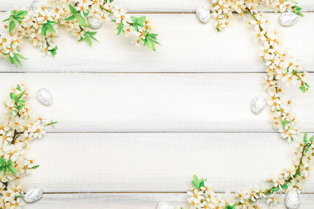 Easter spring background. Sakura flower, white happy easter egg on wooden spring background. Easter wallpaper. Spring holiday concept.の写真素材