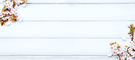 Easter white background. Spring flower border, white happy easter egg on wooden spring background. Easter card. Flat lay.の写真素材