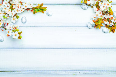 Easter white background. Spring flower border, white happy easter egg on wooden spring background. Easter card. Flat lay.の写真素材
