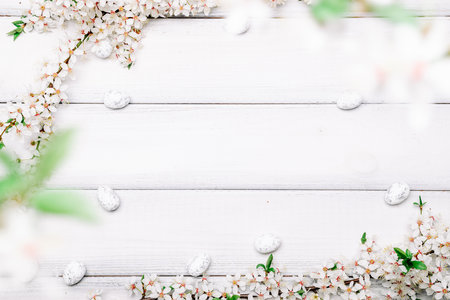 Easter flat. Cherry tree blossom, white happy easter eggs on wood spring background. Springtime concept.の写真素材