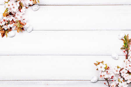 Easter spring background. Sakura flower, white happy easter egg on wooden spring background. Easter wallpaper. Spring holiday concept.の写真素材