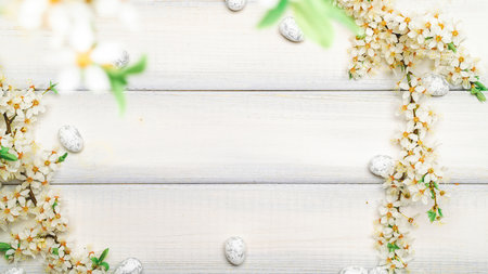 Easter eggs background. May flowers, white happy easter egg on wooden spring background. Easter card. Flat lay.の写真素材