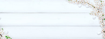Easter flat banner. Cherry tree blossom, white happy easter eggs on wood spring background. Springtime concept.の写真素材