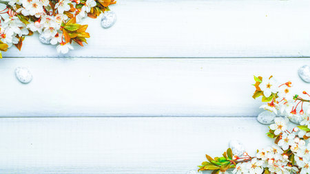Easter flat. Cherry tree blossom, white happy easter eggs on wood spring background. Springtime concept.の写真素材
